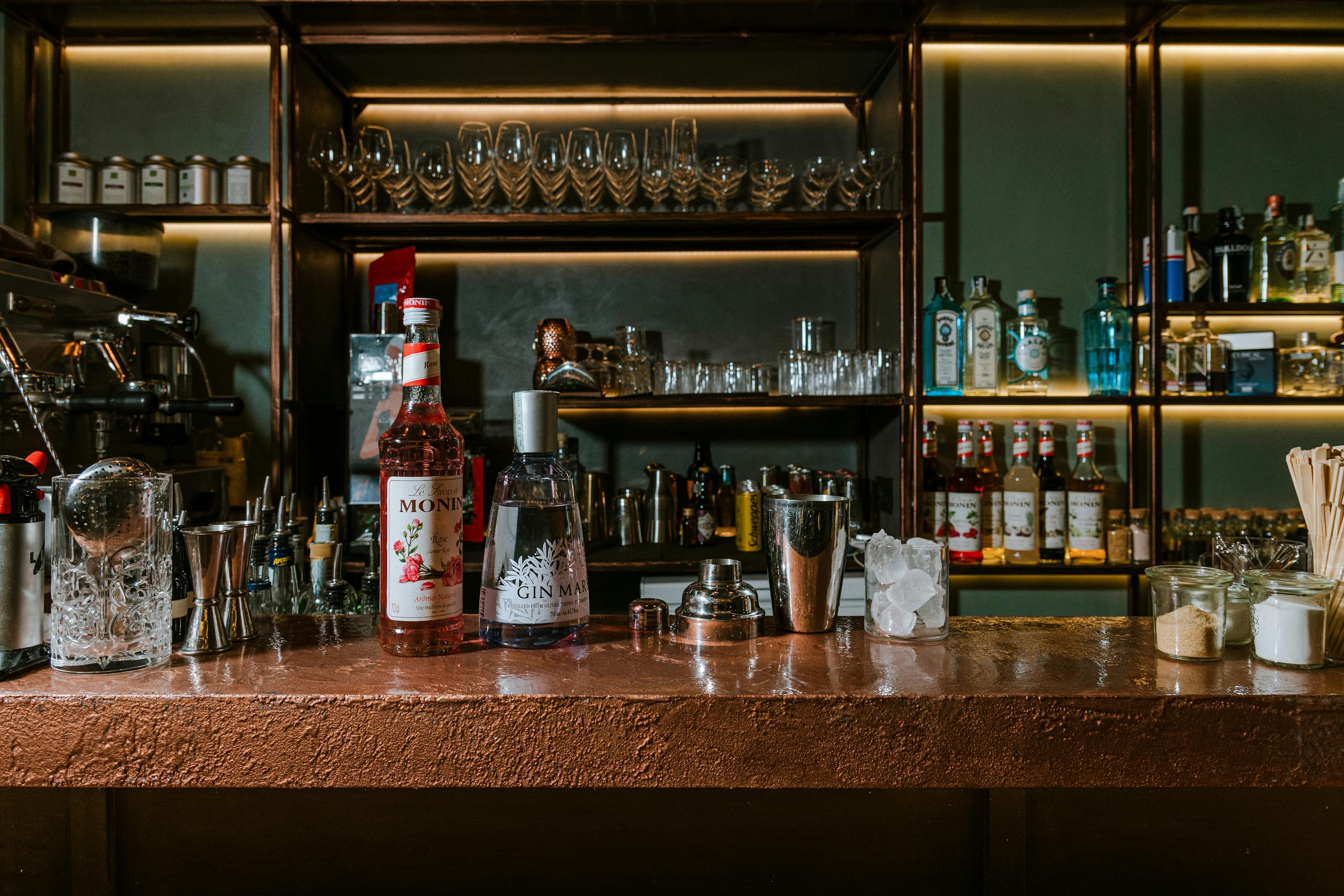 A stylish bar counter with spirits, cocktail tools, and glasses in Naples, Italy.